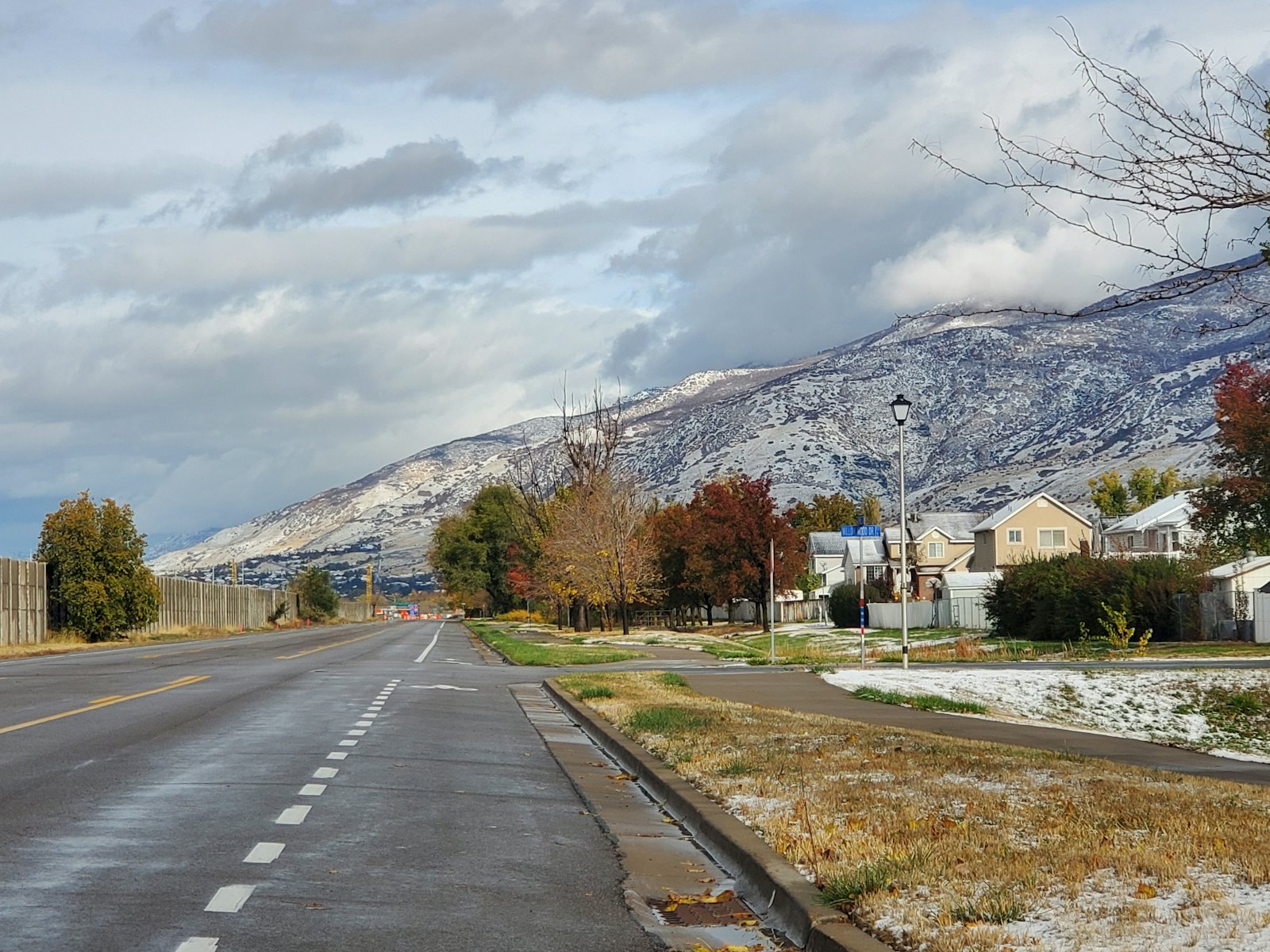 A Centerville, Utah street with homes and mature trees below the snowy Wasatch Mountains